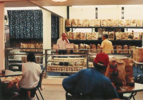 Glass bakery display cases line the front of Pastor Paul's Mission Grocery Shelf 1986.