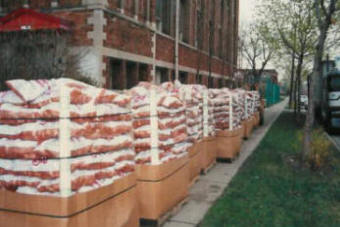 A semi truckload of totes of 10 pound bags of potatoes line the sidewalk for the Easter Holiday GiveAway.